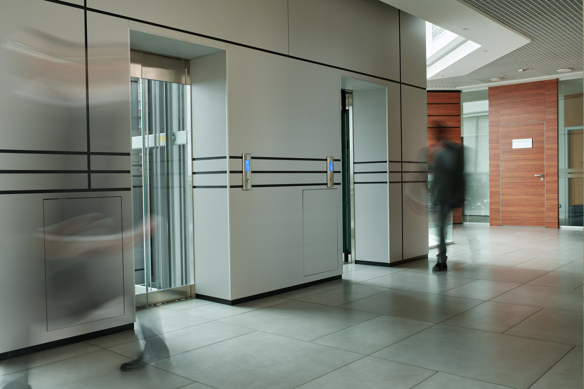 Part of corridor with blurred silhouettes of two businessmen